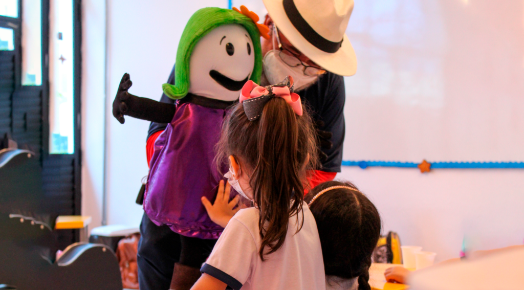 professor de musicalização realizando uma atividade de projeto pedagógico em sala de aula com crianças da Educação Infantil.